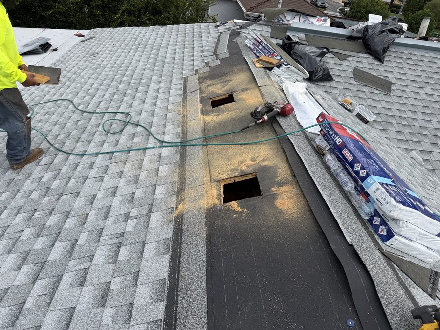Ridge vent openings cut into a shingle roof