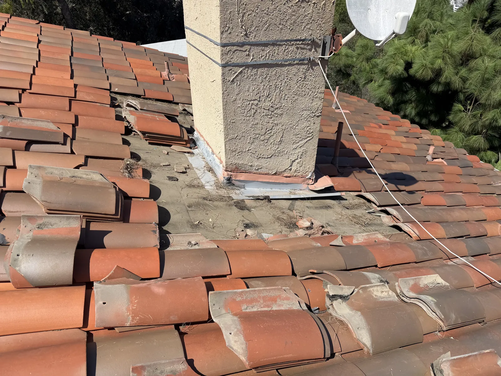 S-tile lifted around the base of a chimney