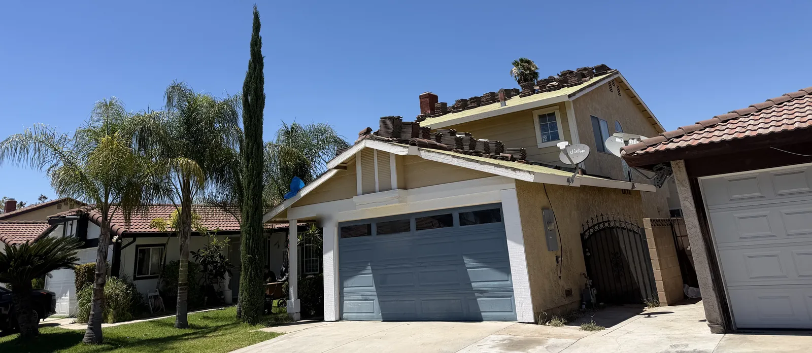 Two-story home with tile loaded on the roof for a reroof