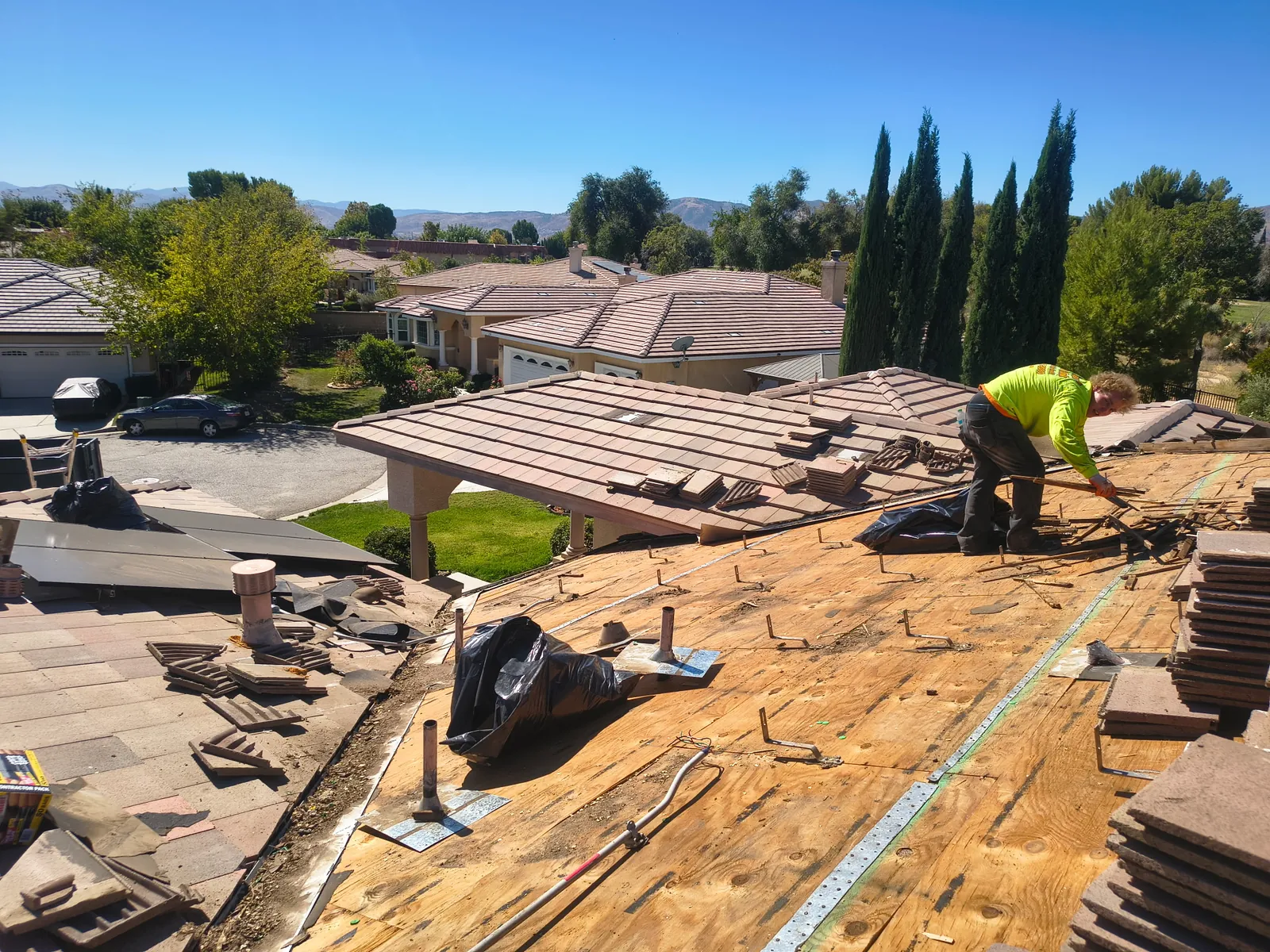 Tile stacked on a stripped roof deck during a lift and relay