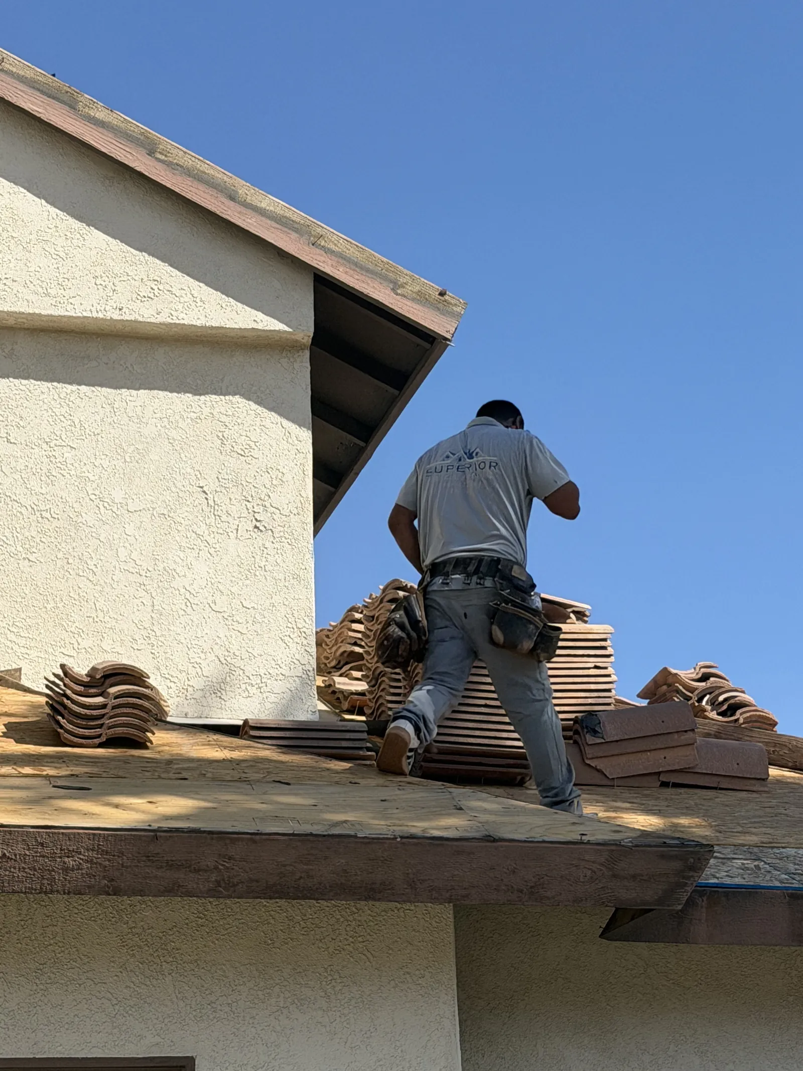 Carrying tile up onto the deck at the edge of the roof