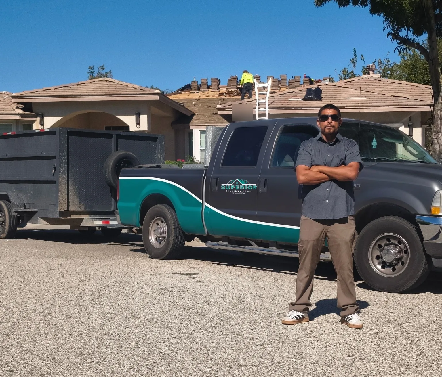 Salvador, owner of Superior Roof Service, with the company truck and trailer outside a job