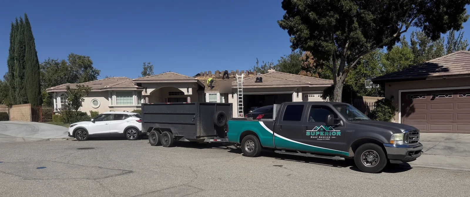 Superior Roof Service truck towing a trailer outside a home