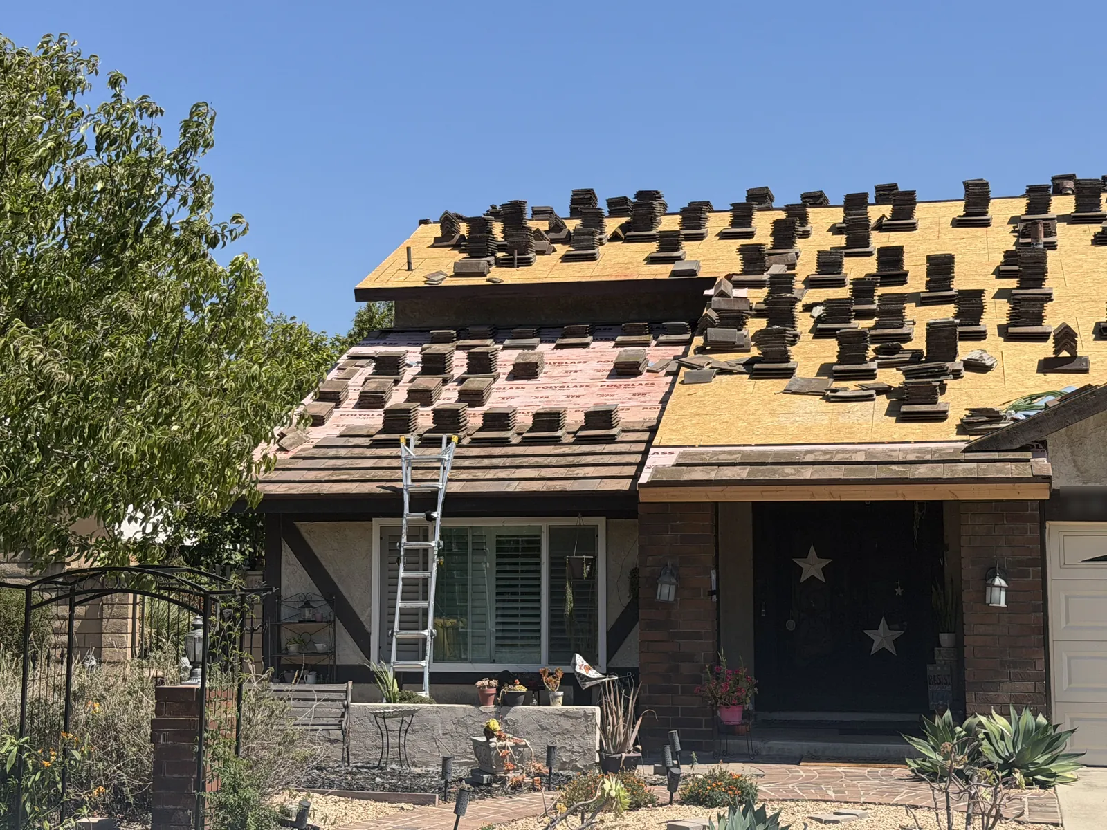 Two-story home mid tile reroof: new decking, Polyglass underlayment and tile stacked on the roof
